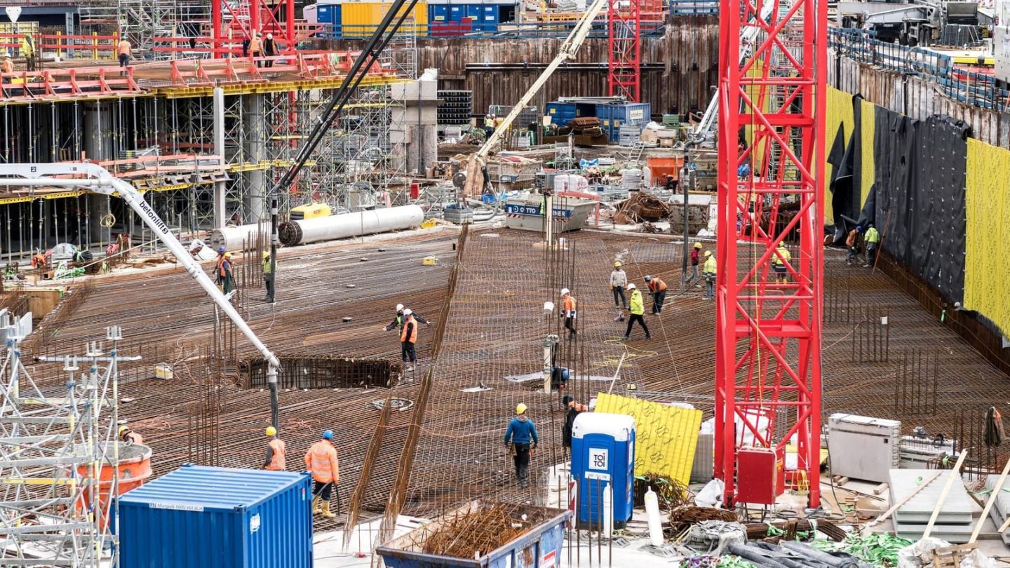 Große Baustelle mit Betonpumpe und Kran während der Betonage